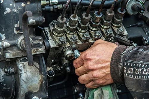 Mechanic adjusting an engine component in the workshop